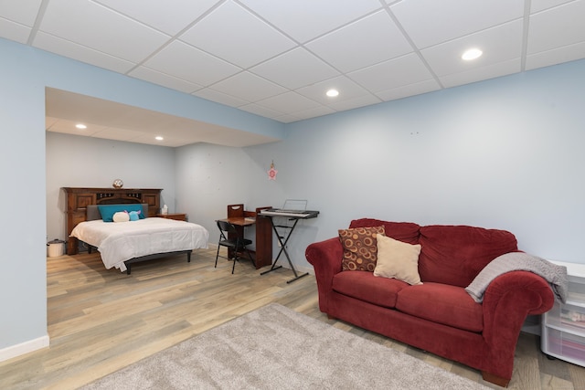 bedroom with a drop ceiling, wood finished floors, and recessed lighting