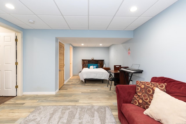 bedroom featuring wood finished floors, baseboards, a drop ceiling, and recessed lighting