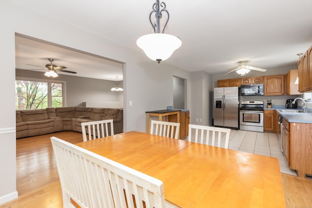 dining space with ceiling fan, light wood-style floors, and baseboards