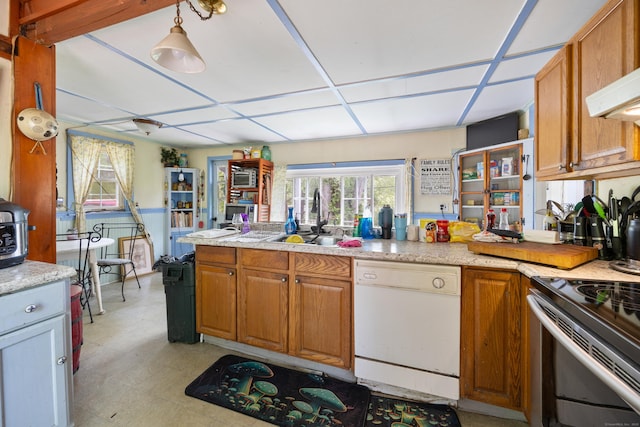 kitchen with white dishwasher, a sink, electric stove, and brown cabinets
