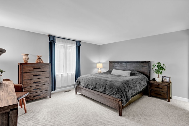 bedroom featuring light colored carpet and baseboards