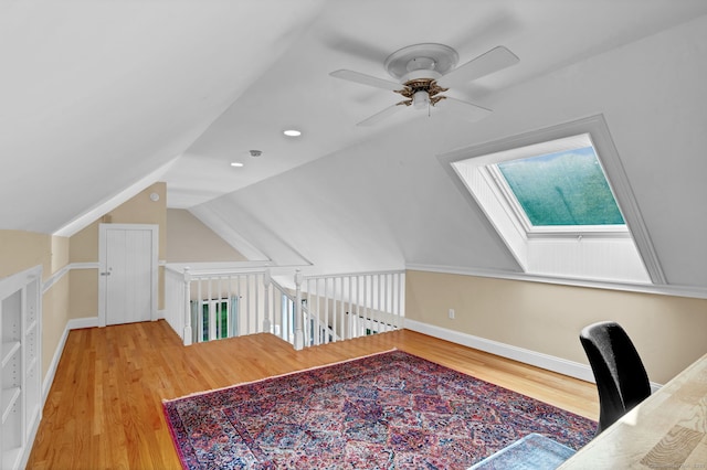 office space featuring wood finished floors, vaulted ceiling, a ceiling fan, and baseboards