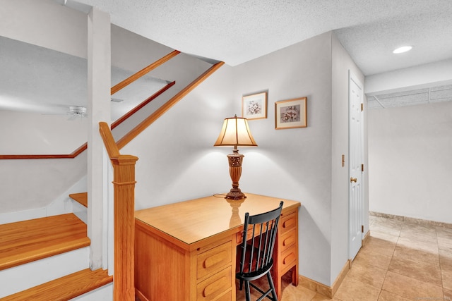 stairway featuring a textured ceiling, baseboards, and tile patterned floors
