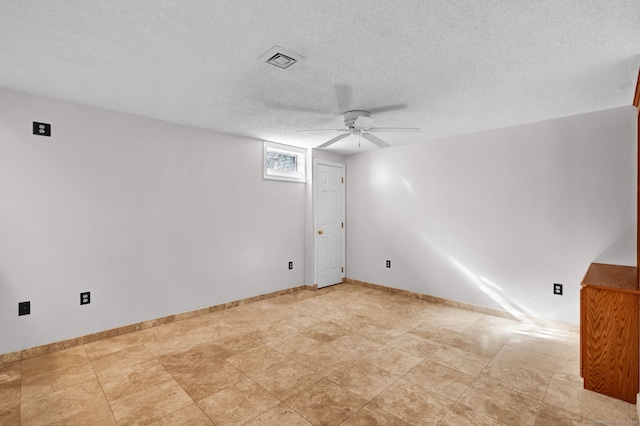 spare room featuring a ceiling fan, a textured ceiling, and baseboards