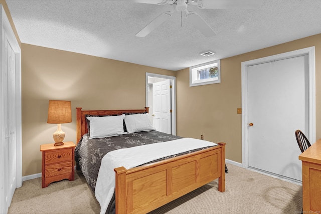 bedroom featuring light colored carpet, a textured ceiling, baseboards, and a ceiling fan