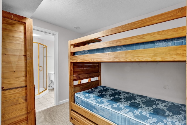 bedroom featuring light carpet, a textured ceiling, and light tile patterned flooring