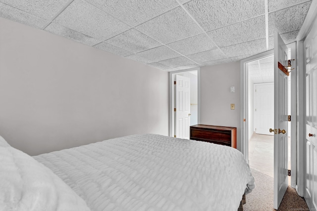 carpeted bedroom with a drop ceiling