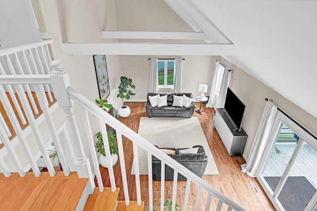 staircase with wood finished floors and plenty of natural light