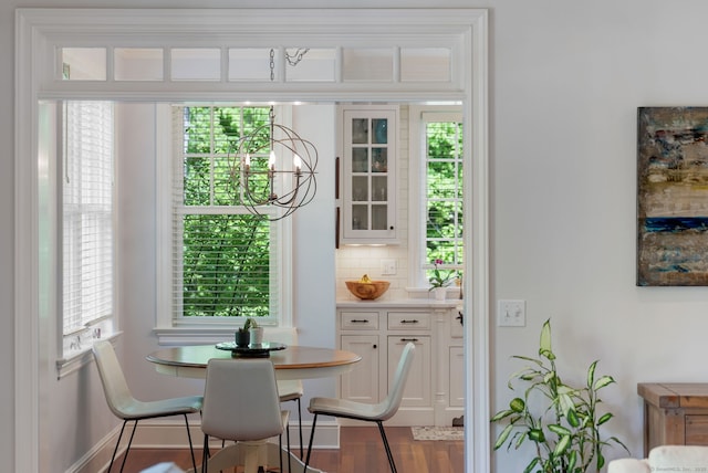 dining space featuring plenty of natural light, wood finished floors, and a chandelier