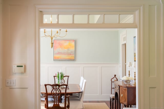 dining space with a decorative wall and a wainscoted wall