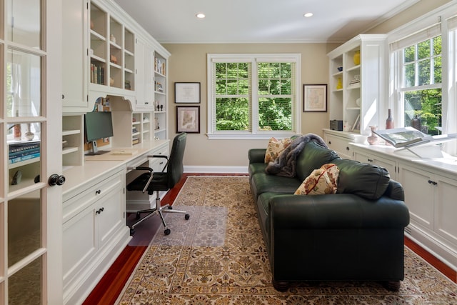 office area with built in study area, dark wood-type flooring, crown molding, recessed lighting, and baseboards