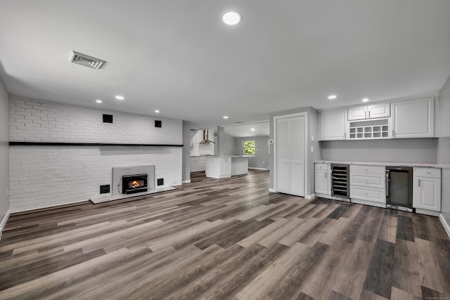 779 New Britain Ave, Rocky Hill, CT 06067 - unfurnished living room featuring wine cooler, a bar, recessed lighting, a fireplace, and dark wood-style flooring