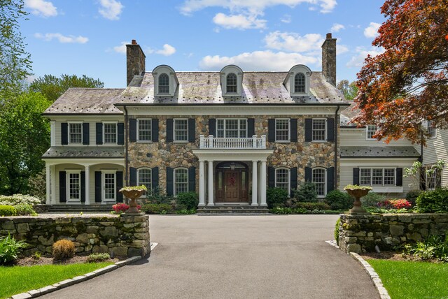 68 Woods End Rd, New Canaan, CT 06840 - colonial home featuring a chimney, a balcony, stone siding, and a high end roof