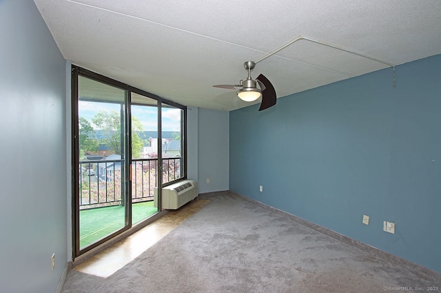 140 Captain Thomas Blvd Unit 307, West Haven, CT 06516 - carpeted empty room featuring floor to ceiling windows, an AC wall unit, a ceiling fan, a textured ceiling, and baseboards