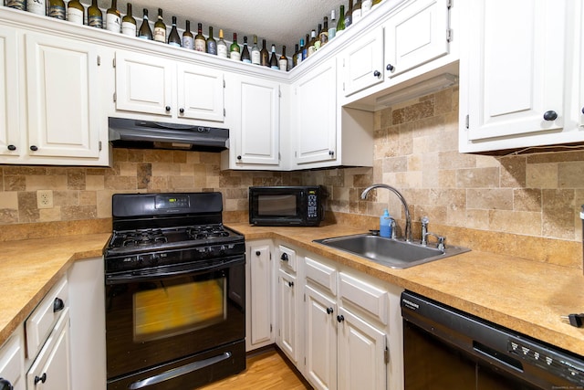 11 Byrne Ct Unit C2, Farmington, CT 06032 - kitchen featuring black appliances, under cabinet range hood, a sink, light countertops, and white cabinets
