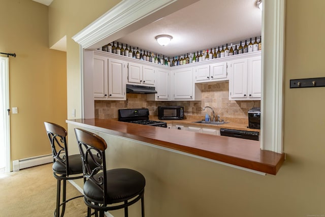 11 Byrne Ct Unit C2, Farmington, CT 06032 - kitchen with black appliances, under cabinet range hood, a sink, baseboard heating, and a breakfast bar