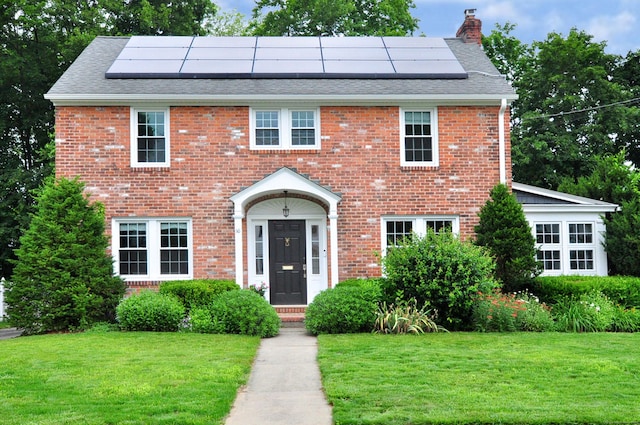 16 Ridgewood Rd, Windsor, CT 06095 - colonial inspired home with a chimney, a front lawn, and roof mounted solar panels