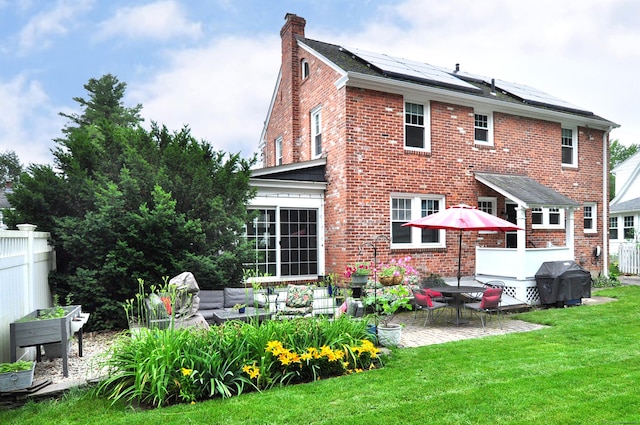 16 Ridgewood Rd, Windsor, CT 06095 - rear view of property with a patio, solar panels, brick siding, and a chimney