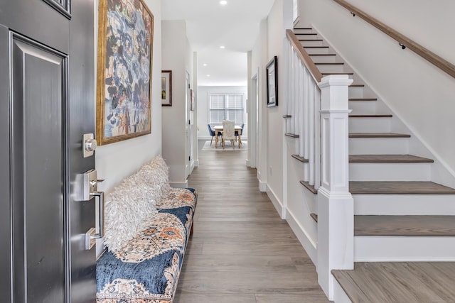 foyer entrance with wood finished floors, recessed lighting, stairs, and baseboards