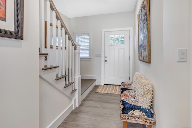 entryway featuring stairway, light wood finished floors, and baseboards