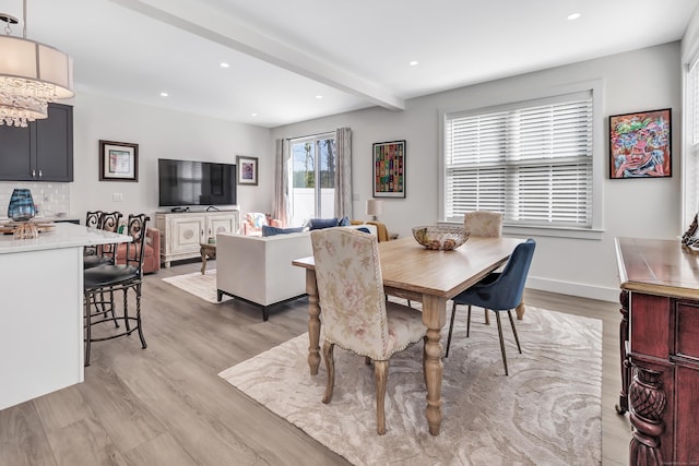 dining space with light wood-type flooring, a chandelier, recessed lighting, beam ceiling, and baseboards