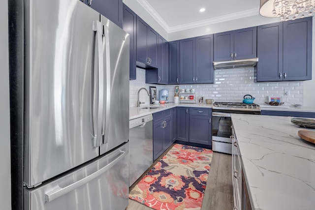 kitchen with stainless steel appliances, under cabinet range hood, ornamental molding, blue cabinets, and a sink