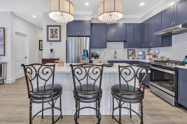 kitchen with stainless steel appliances, a sink, a kitchen bar, decorative backsplash, and ornamental molding