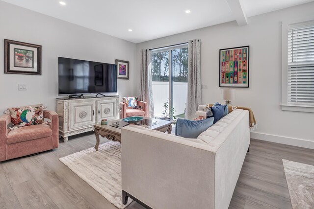 living room featuring wood finished floors, baseboards, beamed ceiling, and recessed lighting
