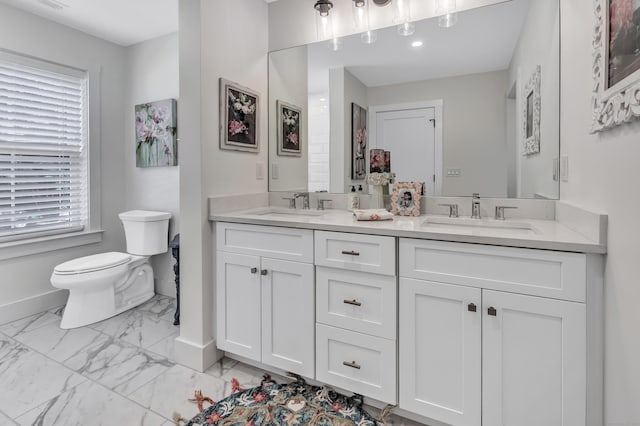 bathroom with baseboards, toilet, marble look tiles, and double vanity