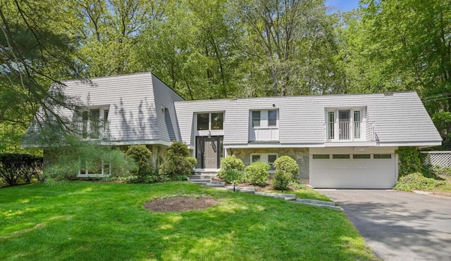 20 Mountain Wood Rd, Stamford, CT 06903 - view of front of home featuring asphalt driveway, a front yard, a garage, stone siding, and a balcony