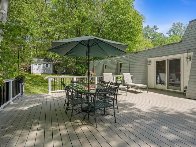 20 Mountain Wood Rd, Stamford, CT 06903 - wooden terrace featuring a storage shed, outdoor dining area, an outbuilding, and a yard