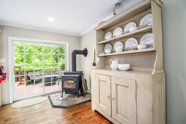 living area featuring ornamental molding, a wood stove, wood finished floors, and recessed lighting