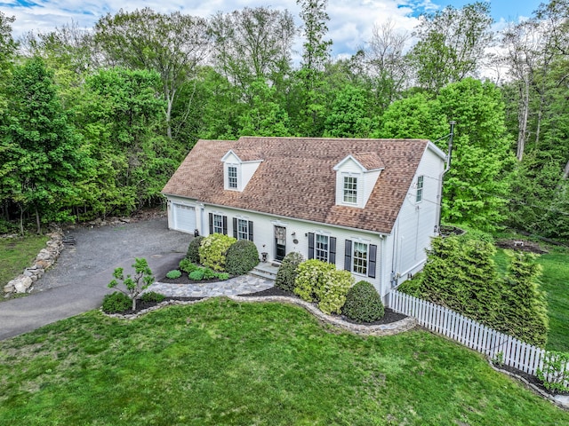 new england style home featuring a garage and driveway
