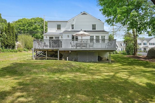 rear view of property with a wooden deck and a yard