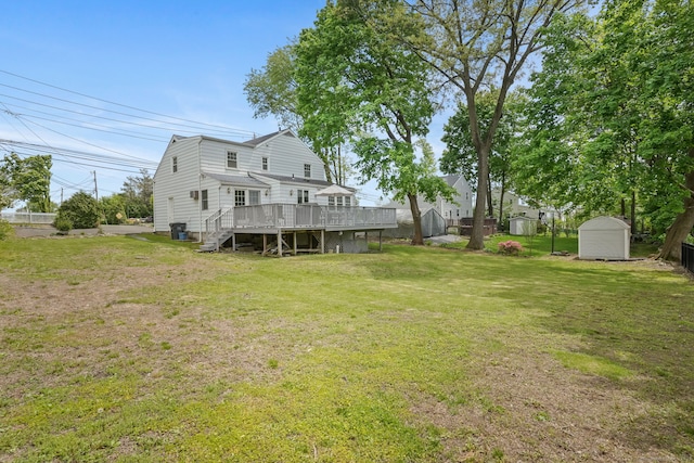 view of grassy yard with a wooden deck, a storage unit, an outdoor structure, and stairs