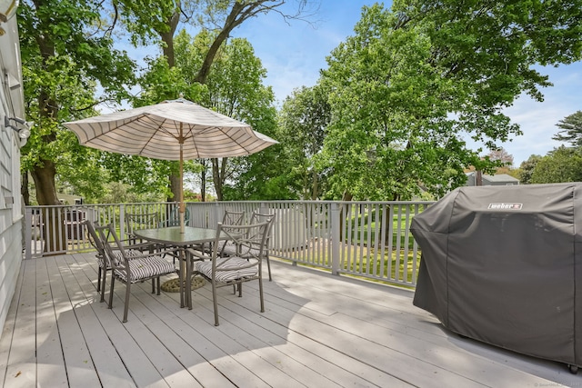 wooden deck with outdoor dining area and grilling area