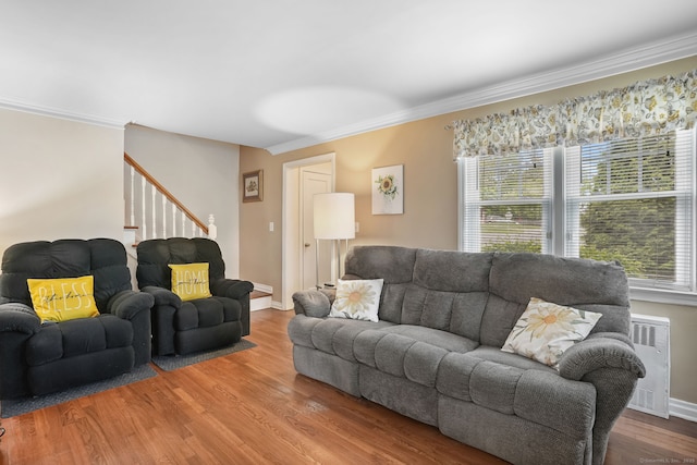 living room featuring radiator heating unit, stairway, ornamental molding, wood finished floors, and baseboards