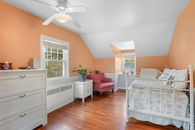 bedroom featuring radiator, light wood-style flooring, lofted ceiling, and ceiling fan
