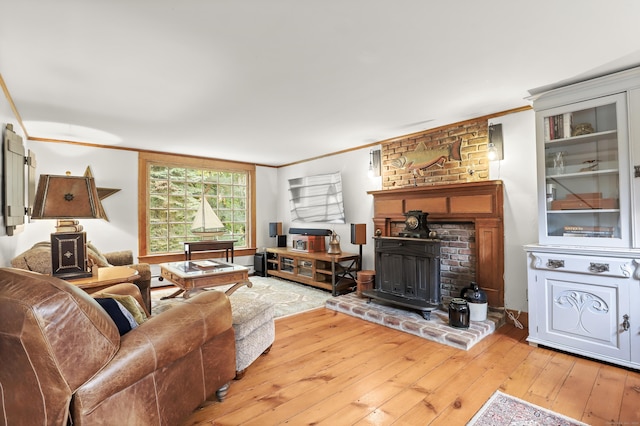 living room featuring crown molding, wood-type flooring, and a wood stove