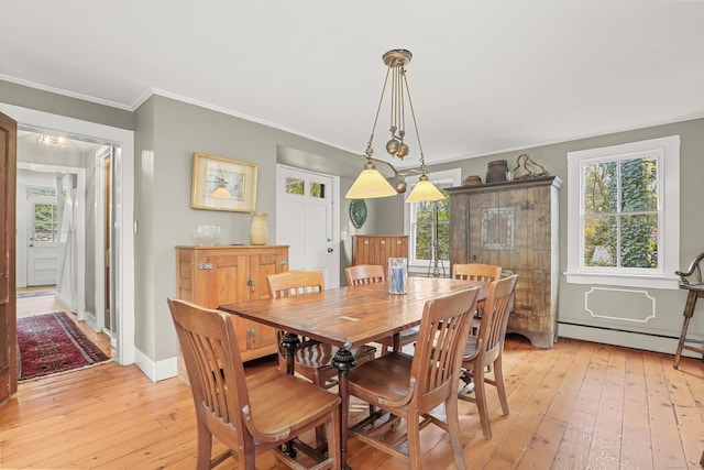 dining room with light wood-style flooring, healthy amount of natural light, crown molding, baseboards, and a baseboard radiator