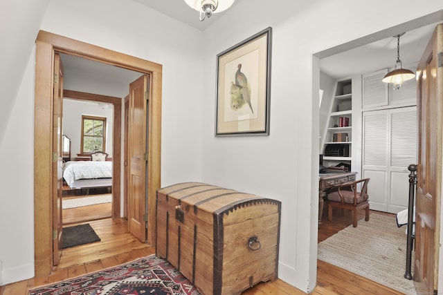corridor with hardwood / wood-style floors and built in features