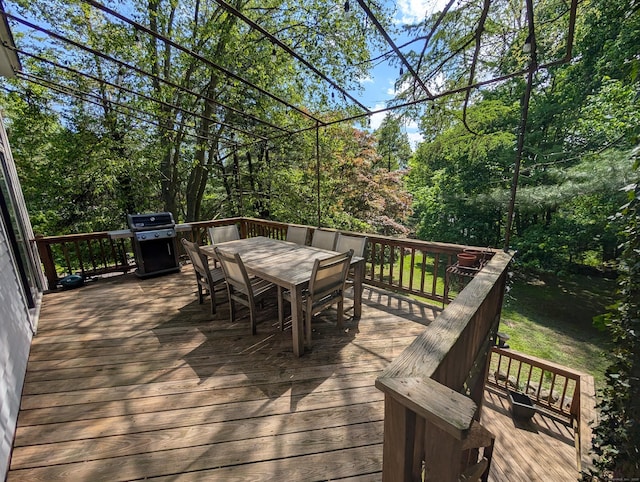 wooden terrace featuring outdoor dining area and grilling area