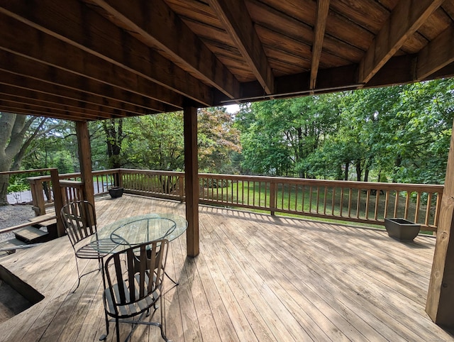 wooden terrace featuring view of wooded area