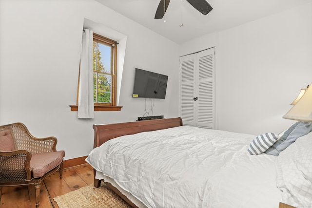 bedroom featuring hardwood / wood-style floors, a closet, baseboards, and ceiling fan