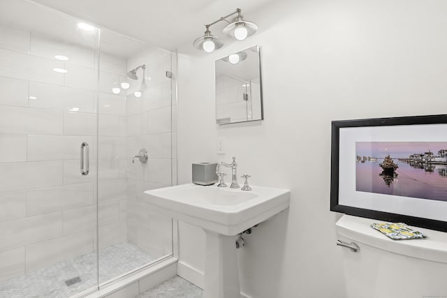 bathroom featuring a shower stall, toilet, and baseboards