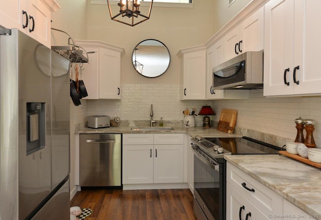 kitchen with stainless steel appliances, a sink, and white cabinets