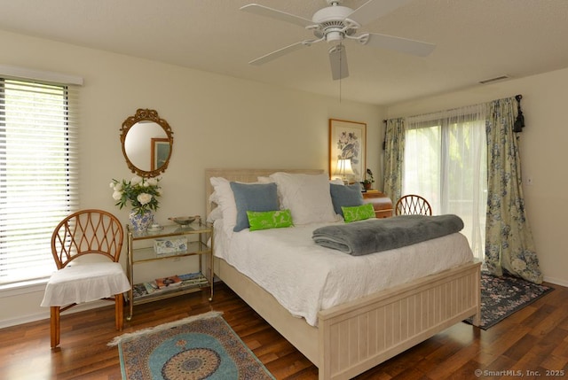 bedroom featuring multiple windows, wood finished floors, ceiling fan, and baseboards