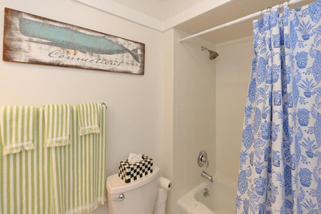 bathroom with toilet and shower / tub combo with curtain