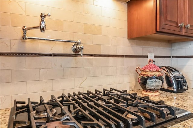 2 Crestview Dr Unit 2, Middlefield, CT 06481 - kitchen view of decorative backsplash, gas stovetop, brown cabinetry, and light stone countertops
