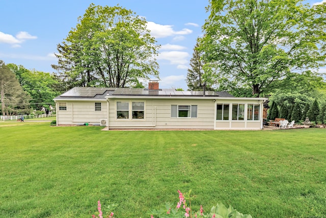 26 Williams Rd, Cheshire, CT 06410 - back of house with roof mounted solar panels, a yard, a chimney, and a sunroom